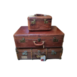 A SET OF FOUR VINTAGE TAN LEATHER GRADUATED SUITCASES Along with a matching vanity case, lined,