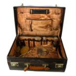 AN EDWARDIAN SILVER AND LEATHER FITTED TRAVEL CASE Comprising a hand mirror, two clothes brushes,