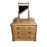 AN EDWARDIAN PINE DRESSING CHEST Having a central mirror and an arrangement of seven drawers, on a