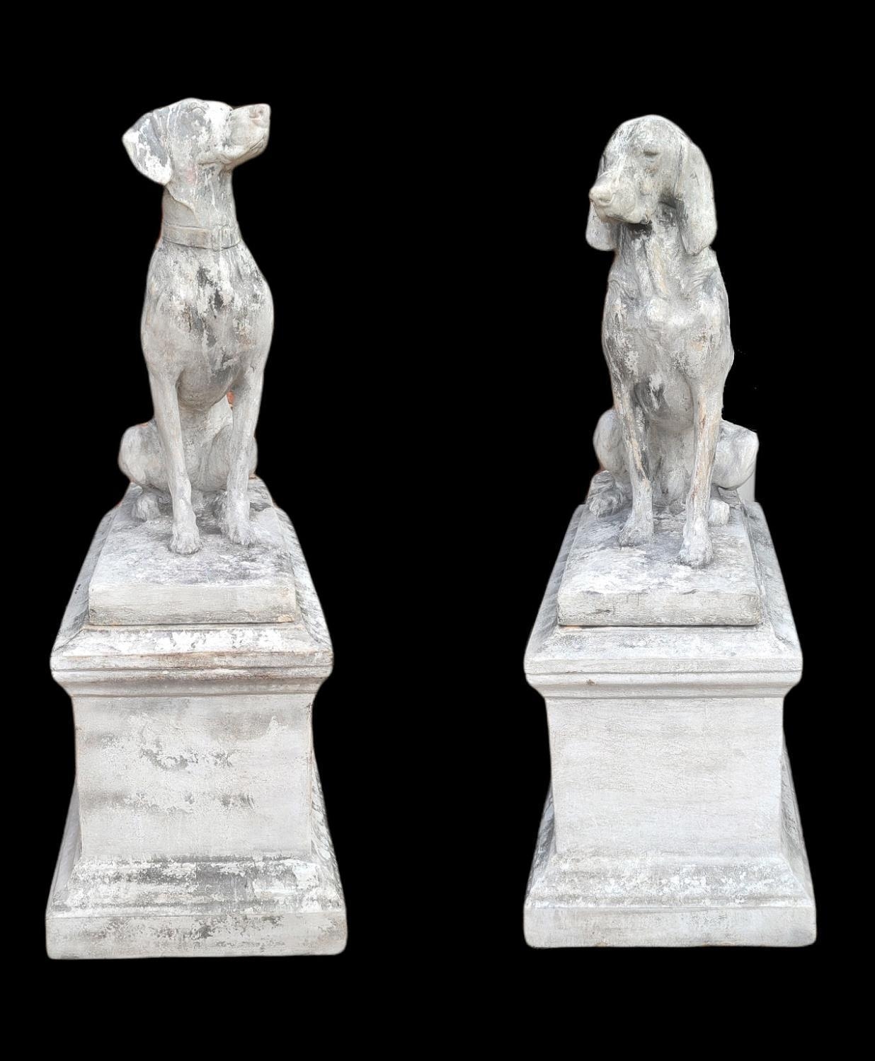A PAIR OF LIFE SIZE STONE STATUES OF HOUNDS SEATED ON PLINTH BASES. (dogs 92cm, plinths w 50cm x d