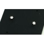 A PAIR OF 20TH CENTURY SILVER AND DIAMOND STUD EARRINGS Each set with a single round cut diamond. (