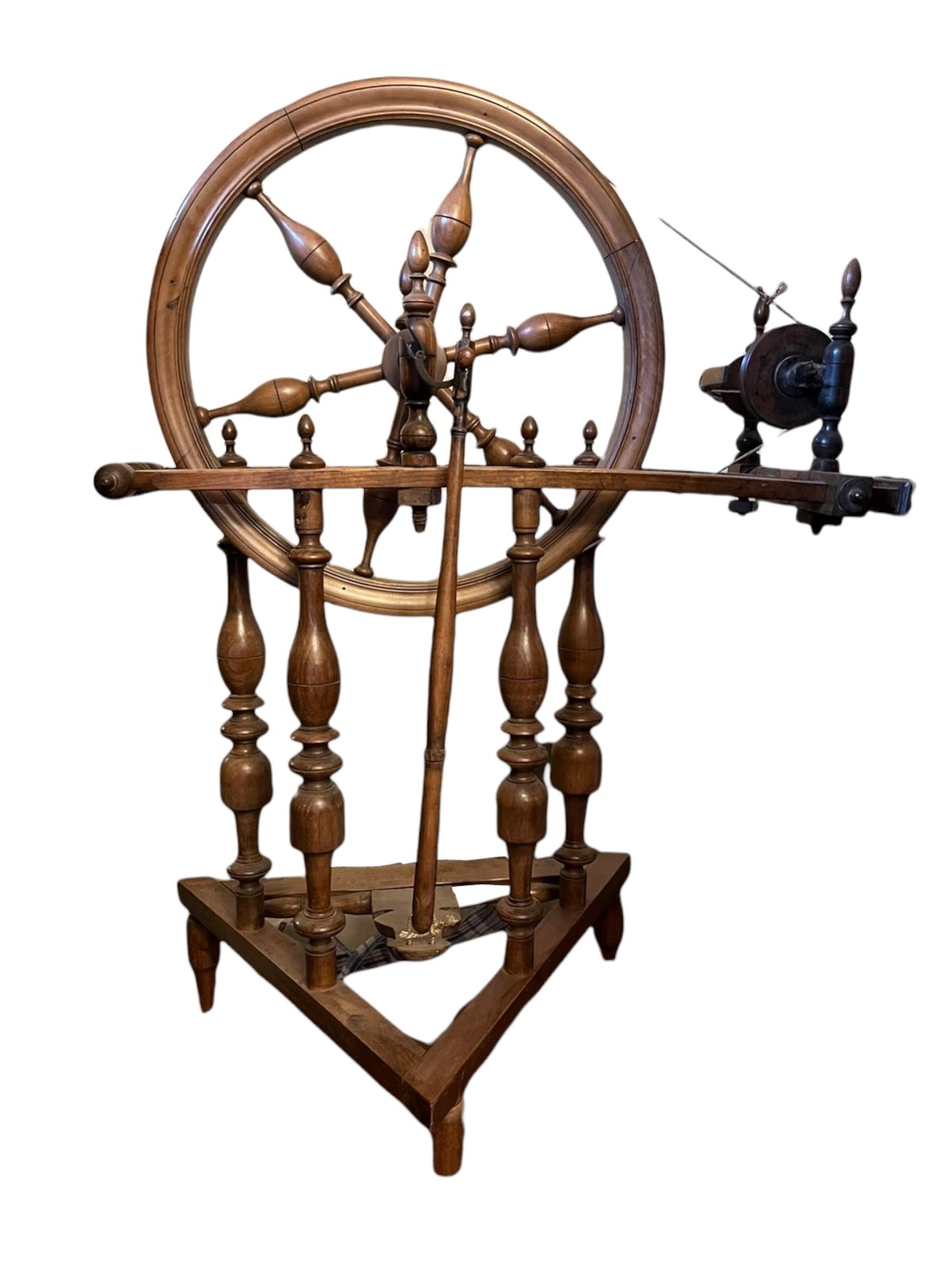A 19TH CENTURY BEECHWOOD TREADLE SPINNING WHEEL Having turned spindles and columns. (74cm x 36cm x