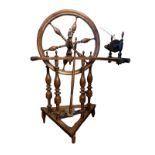A 19TH CENTURY BEECHWOOD TREADLE SPINNING WHEEL Having turned spindles and columns. (74cm x 36cm x