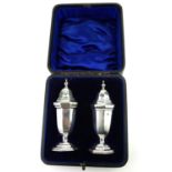 A PAIR OF EDWARDIAN SILVER PEPPERETTES Classical urn form with facets, pierced lid and facets to