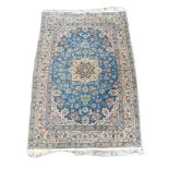 A FINE PERSIAN QUM SILK RUG The central floral field contained within three running borders on a