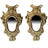 A PAIR OF 18TH/19TH CENTURY CONTINENTAL GILTWOOD CARVED MIRRORS Figured with facial masks, winged