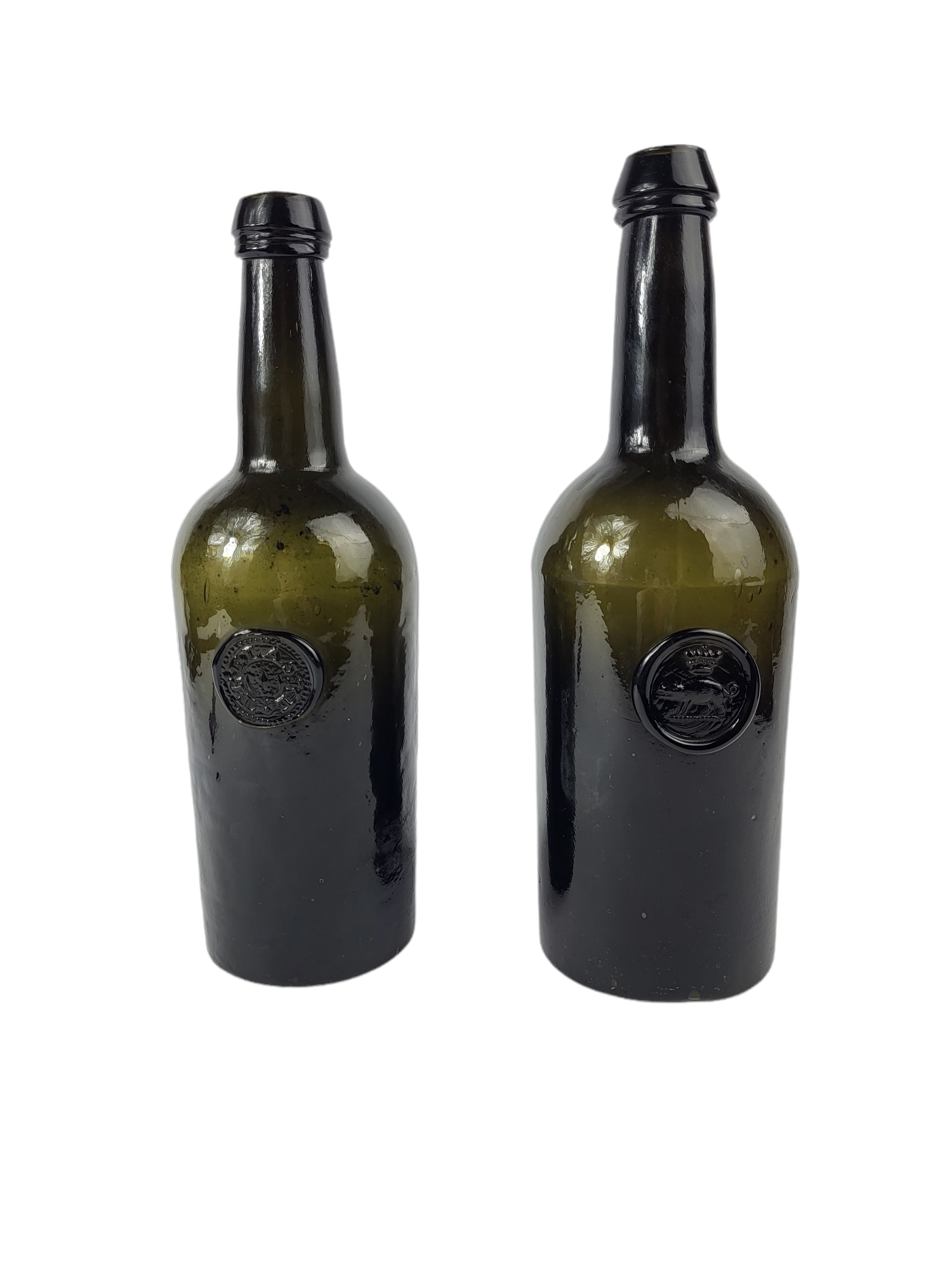 TWO MID 18TH CENTURY DARK GLASS CYLINDER WINE BOTTLES Moulded with circular medallion depicting a