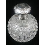 AN EDWARDIAN SILVER AND CUT GLASS SCENT BOTTLE Having an embossed hinge top and glass stopper,