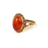 A VINTAGE 9CT GOLD AND AGATE RING The single cabochon cut hardstone in a rope twist gold mount. (