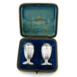 A PAIR OF VICTORIAN SILVER PEPPERETTES Having pierced dome tops and flutes to body, hallmarked
