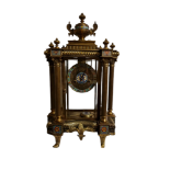A GLASS CASED BRASS AND CLOISONNÉ CLOCK Having ornate columns, complete with pendulum and key. (h
