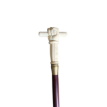 A CARVED POLISHED BONE HANDLED WALKING STICK Depicting a hand holding a stick. (h 94cm) Condition: