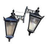A PAIR OF GEORGIAN DESIGN PAINTED ALUMINUM WALL HANGING LANTERN LIGHTS With turned finials above