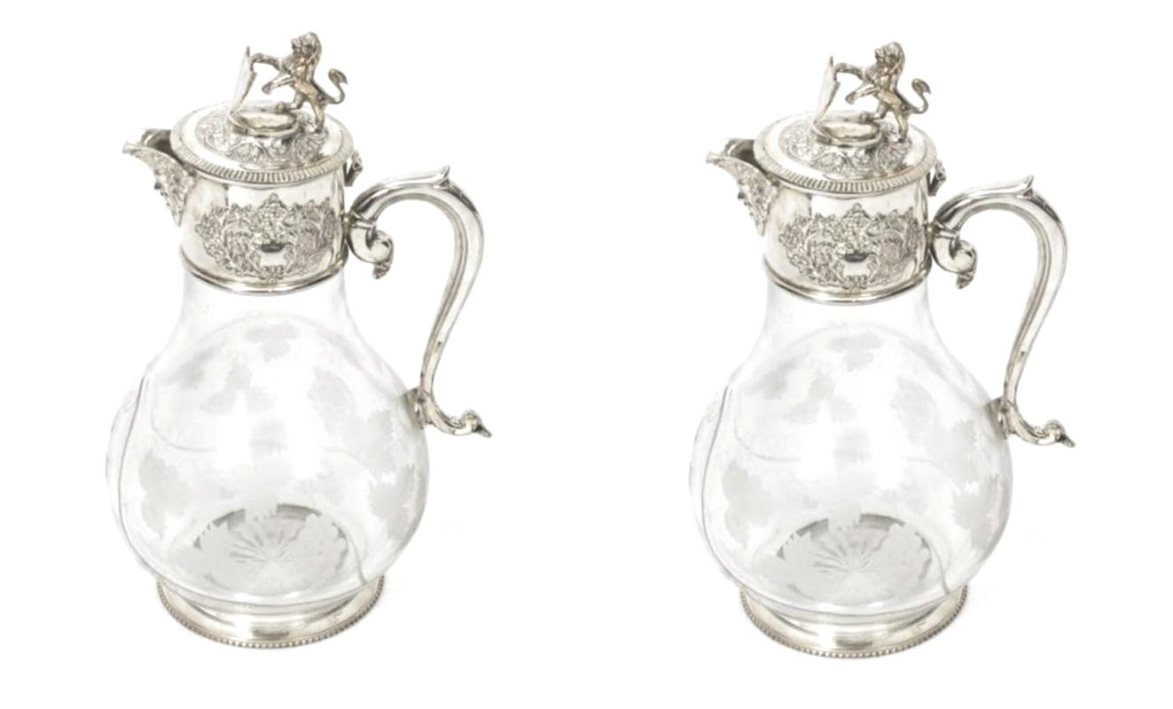 A PAIR OF SILVER PLATED ETCHED GLASS CLARET JUGS, Decorated with a lion holding a shield, Dionysus