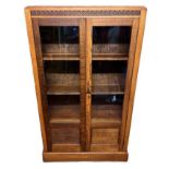 AN EARLY 20TH CENTURY OAK FLOOR STANDING TWO DOOR BOOKCASE Enclosing shelves. (92cm x 27cm x