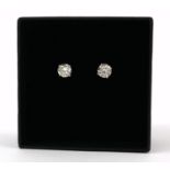 A PAIR OF 18CT WHITE GOLD FOUR CLAW ROUND BRILLIANT CUT DIAMOND STUDS. (Diamonds 1.14ct), Boxed.