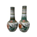 A MATCHED PAIR OF 19TH CENTURY CHINESE FAMILLE ROSE BOTTLE FORM VASES Decorated with pheasants