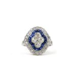 A PLATINUM, SAPPHIRE AND DIAMOND RING. The 4 central diamonds surrounded by calibre cut sapphires