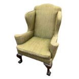 A 19TH CENTURY WING ARMCHAIR In pale green fabric upholstery, raised on heavy mahogany cabriole legs