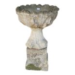 A RECONSTITUTED STONE PLANTER On plinth base. (83cm) Condition: good but weathered