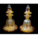 A PAIR OF 19TH CENTURY BOHEMIAN AMBER FLASHED CUT CRYSTAL GLASS SCENT FLASKS AND STOPPERS The bodies