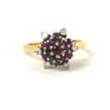 A VINTAGE 18CT GOLD, RUBY AND DIAMOND CLUSTER RING Having an arrangement of round cut rubies edged