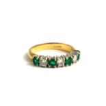 AN 18CT GOLD, EMERALD AND DIAMOND HALF ETERNITY RING The row of round cut emeralds interspersed with