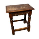 AN ANTIQUE OAK JOINED STOOL With carved and pierced apron, on square and turned legs. (47cm x 28cm x