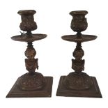 A PAIR OF 19TH CENTURY CONTINENTAL PATINATED BRONZE CHAMBER CANDLESTICKS Each column cast with a