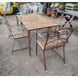 A HEAVY WROUGHT IRON GARDEN TABLE AND FOUR ARMCHAIRS Along with a two seat open arm bench.