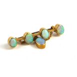 AN EARLY 20TH CENTURY 18CT GOLD AND OPAL BROOCH The row of cabochon cut opals and an opal drop. (