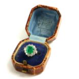 AN 18CT WHITE GOLD, EMERALD AND DIAMOND RING Having a central rectangular cushion cut emerald