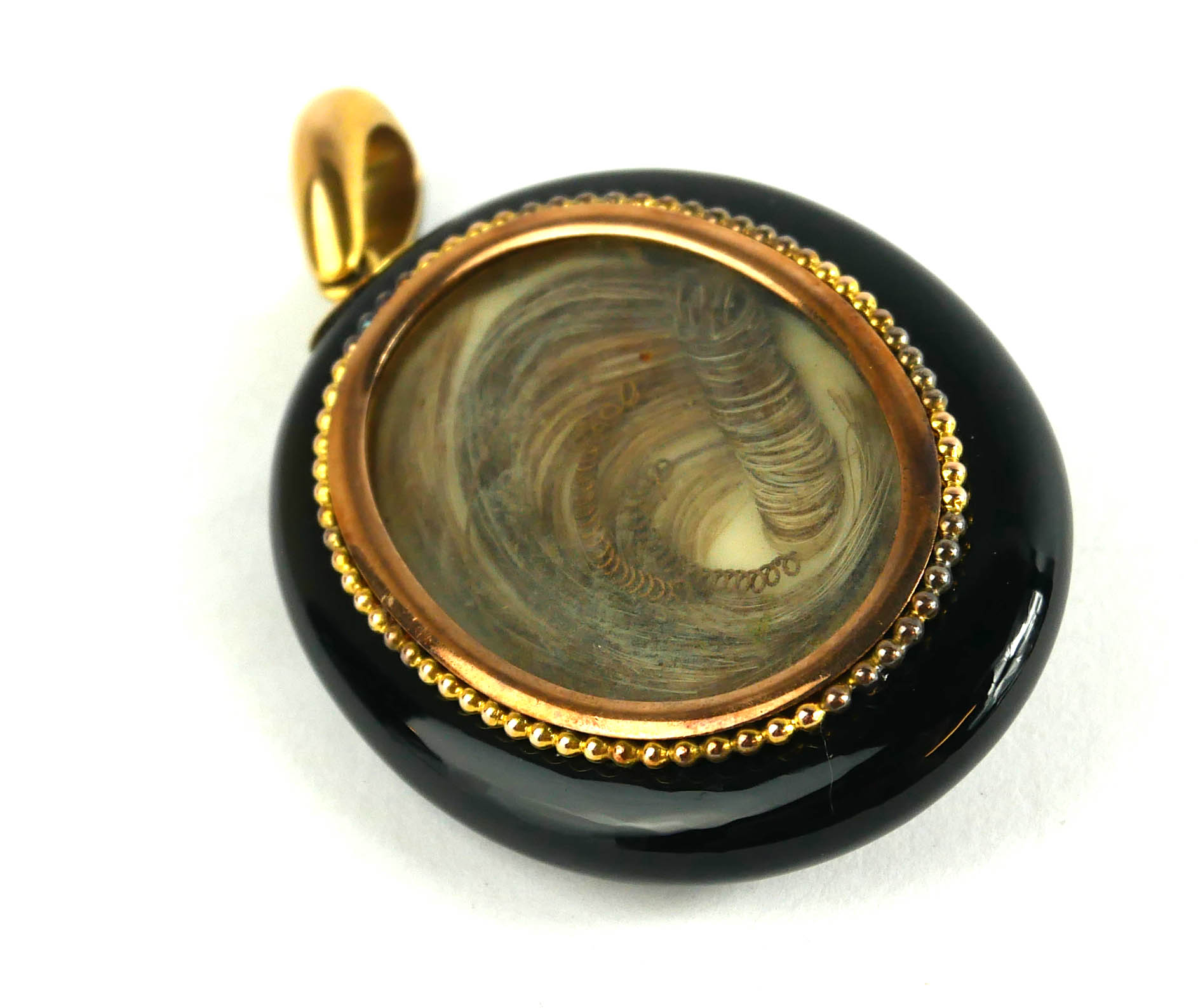 A VICTORIAN YELLOW METAL, JET AND SEED PEARL OVAL MOURNING LOCKET The starburst design to front