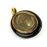 A VICTORIAN YELLOW METAL, JET AND SEED PEARL OVAL MOURNING LOCKET The starburst design to front