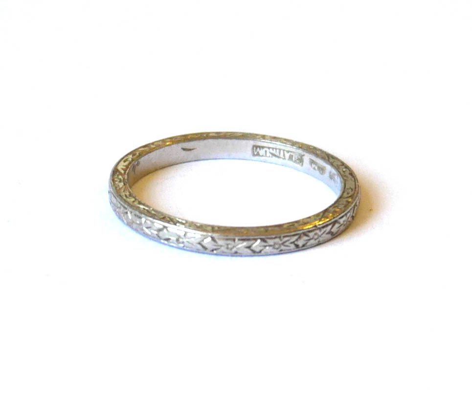 A PLATINUM WEDDING BAND RING With engraved decoration. (size I/J, approx weight 2.6g) Condition :