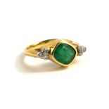 A YELLOW METAL AND NATURAL EMERALD AND DIAMOND RING The central rectangular faceted cut emerald