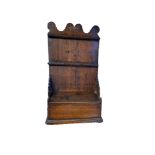 AN 18TH CENTURY OAK SPOON RACK AND CANDLEBOX Having a carved scrolled top with two pierced shelf