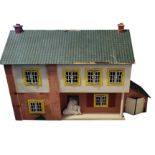 A VINTAGE SCRATCH BUILT WOODEN DOLLS HOUSE Having a pitched roof, side garage, removable back and