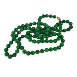 A GREEN ROUND JADE BEADS NECKLACE WITH YELLOW GOLD CLASP. (length 63cm) Condition: good