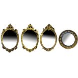 A PAIR OF VINTAGE OVAL GILT FRAMED CHERUBS MIRRORS Together with an oval Rococo style smaller filter