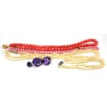 A VINTAGE YELLOW METAL AND CORAL NECKLACE The row of spherical beads with yellow metal clasp,