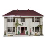 AN EARLY 20TH CENTURY TINPLATE DOLLS HOUSE Having a removable red plastic roof, sliding front,