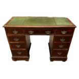 AN EDWARDIAN MAHOGANY TWIN PEDESTAL DESK With green tooled leather surface above arrangement of nine
