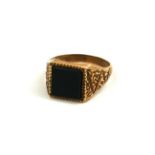 A VINTAGE 9CT GOLD AND BLACK ONYX GENT'S SIGNET RING Having a square central onyx panel and engraved