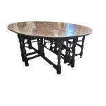 A 17TH CENTURY DESIGN OAK WAKE TABLE Having a double gate leg action, raised on square and turned