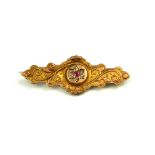 AN EARLY 20TH CENTURY 9CT GOLD, DIAMOND AND RUBY BROOCH Scrolled decoration set with a central