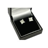 A PAIR OF 18CT WHITE GOLD EIGHT STONE INVISIBLE SET PRINCESS CUT DIAMOND SCREW BACK STUDS, boxed. (
