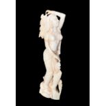 AN ART DECO PERIOD IVORY STATUE, SEMICLAD MAIDEN IN EGYPTAN DRESS. (23cm)