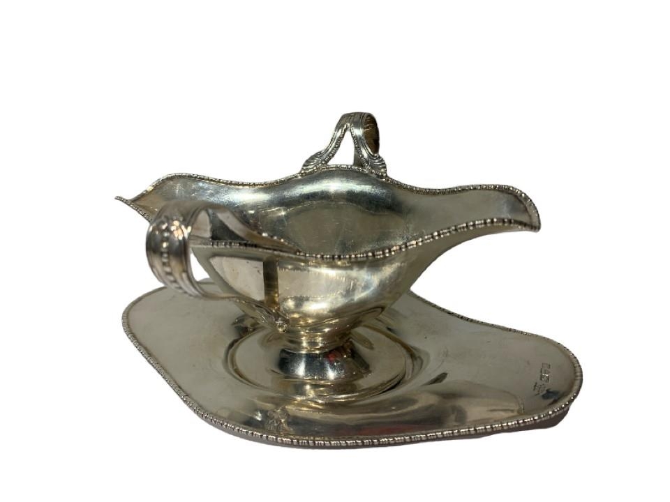 BARKER BROTHERS, AN EDWARDIAN SILVER DOUBLE LIPPED SAUCE BOAT AND TRAY Assayed Chester, 1908. (18.