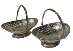 MAPPIN & WEBB, A PAIR OF SILVER SWING HANDLED BASKETS Having bead and pierced decoration raised upon